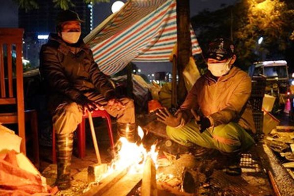 Người Hà Nội đốt lửa sưởi ấm, chật vật mưu sinh xuyên đêm mưa rét kỷ lục